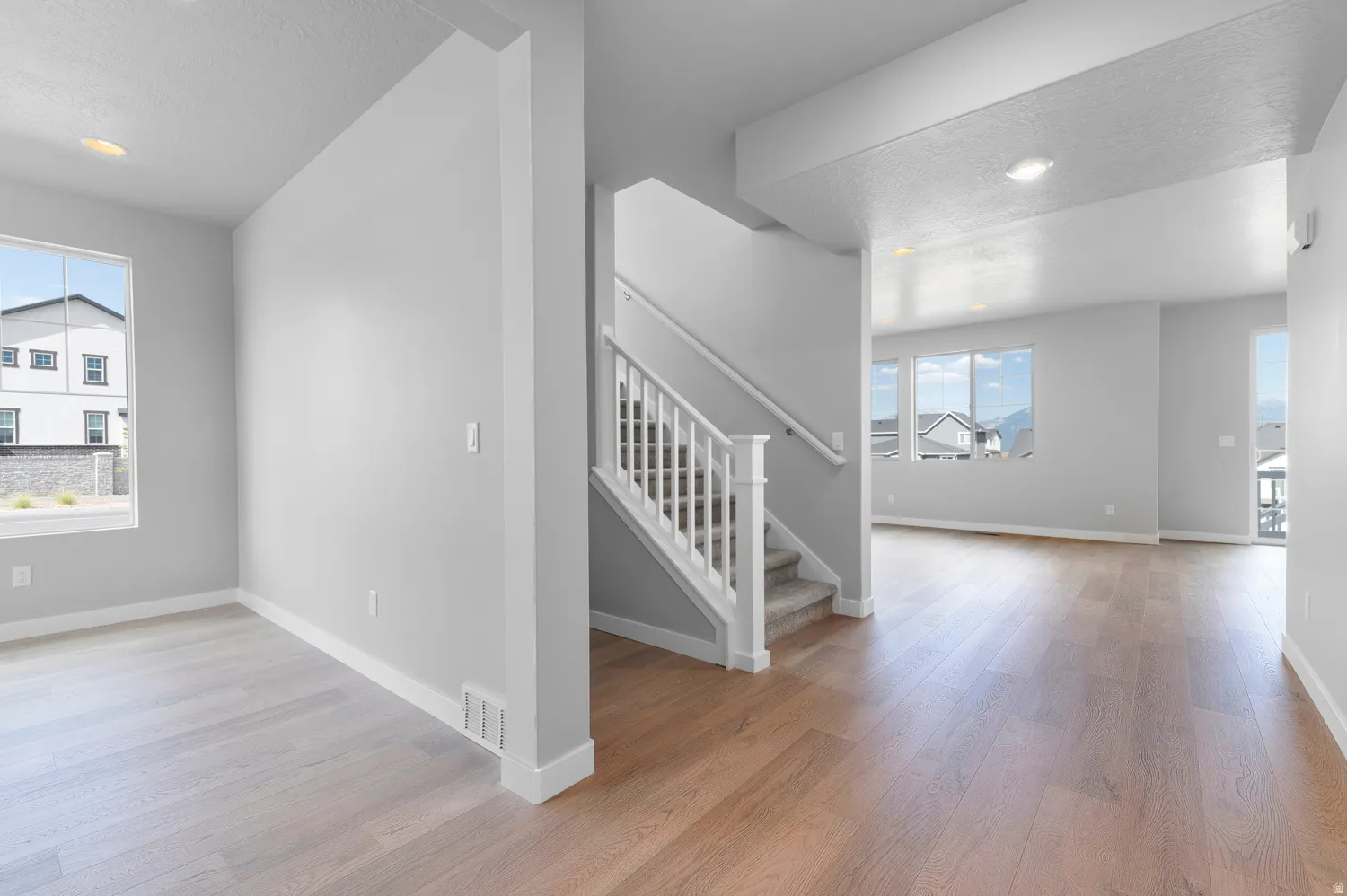 Central staircase with white balusters and carpeted treads