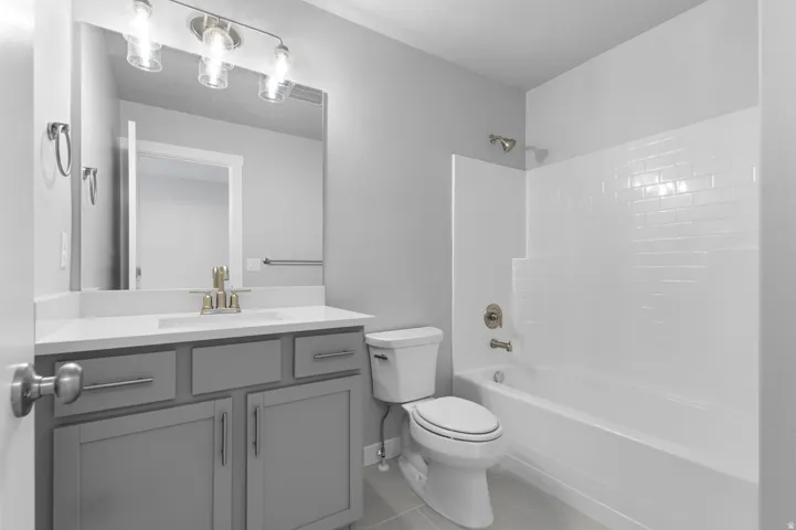 Bathroom featuring a single vanity with gray cabinetry, a white countertop, and a rectangular undermount sink
