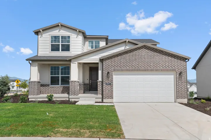 Modern two-story residence featuring a brick and siding exterior, an attached two-car garage, a covered front porch, a concrete driveway, and a landscaped front yard