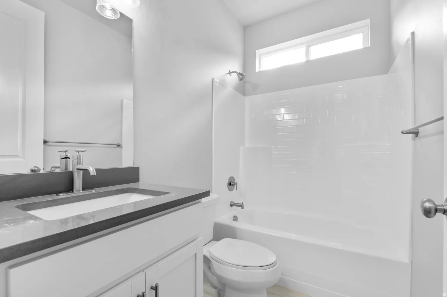 Bathroom featuring a white vanity with a dark countertop, an undermount sink, and a single-handle faucet