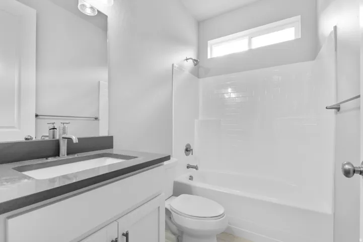Bathroom featuring a white vanity with a dark countertop, an undermount sink, and a single-handle faucet