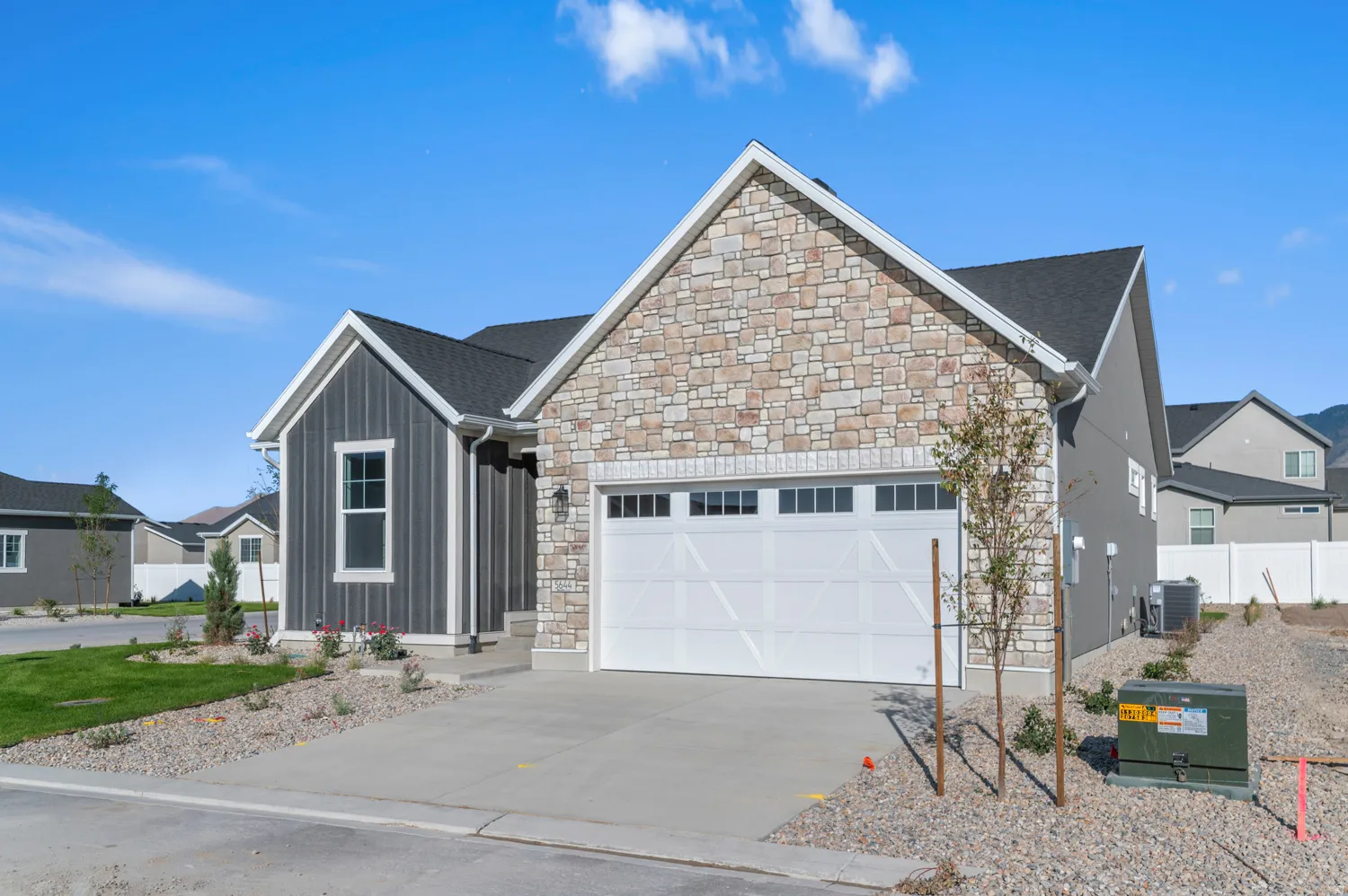 Modern exterior featuring stacked stone and vertical siding accents