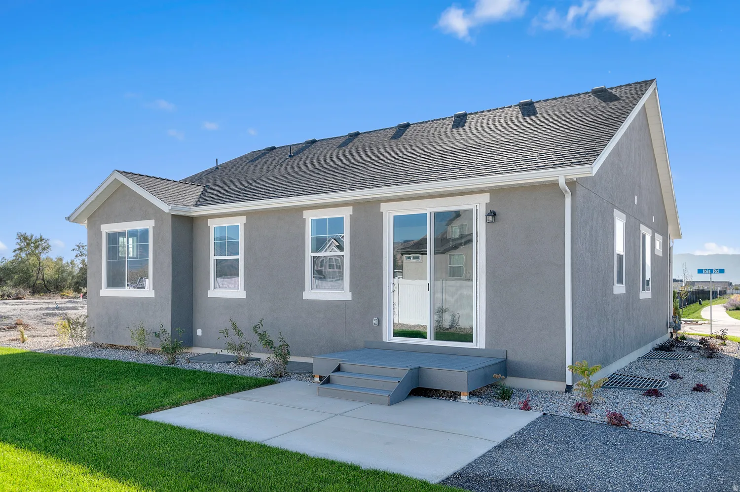 Stucco exterior with a dark shingle roof and white trim