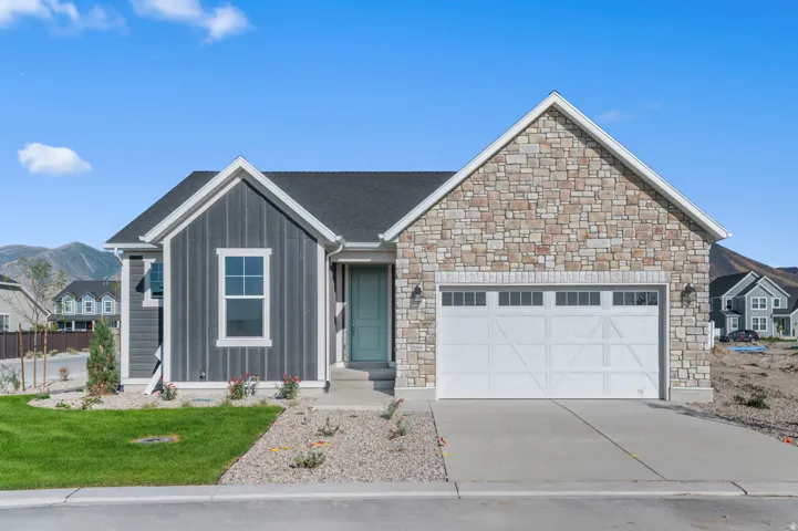 Contemporary ranch-style residence featuring a stone facade and vertical siding accents