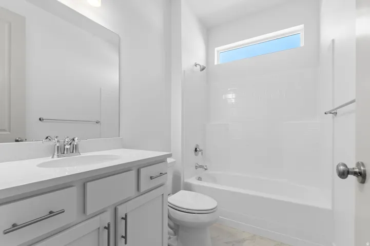 Modern bathroom featuring a white vanity with an undermount sink, chrome faucet, and ample counter space