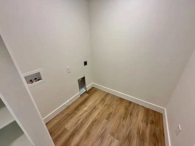 Finished interior space featuring warm wood-finish flooring, clean white walls with crown molding, and recessed lighting
