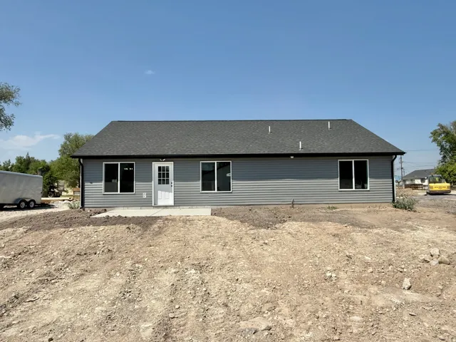 New construction ranch-style home featuring clean-lined siding exterior, multiple large windows with dark frames, and a gable roof with architectural shingles