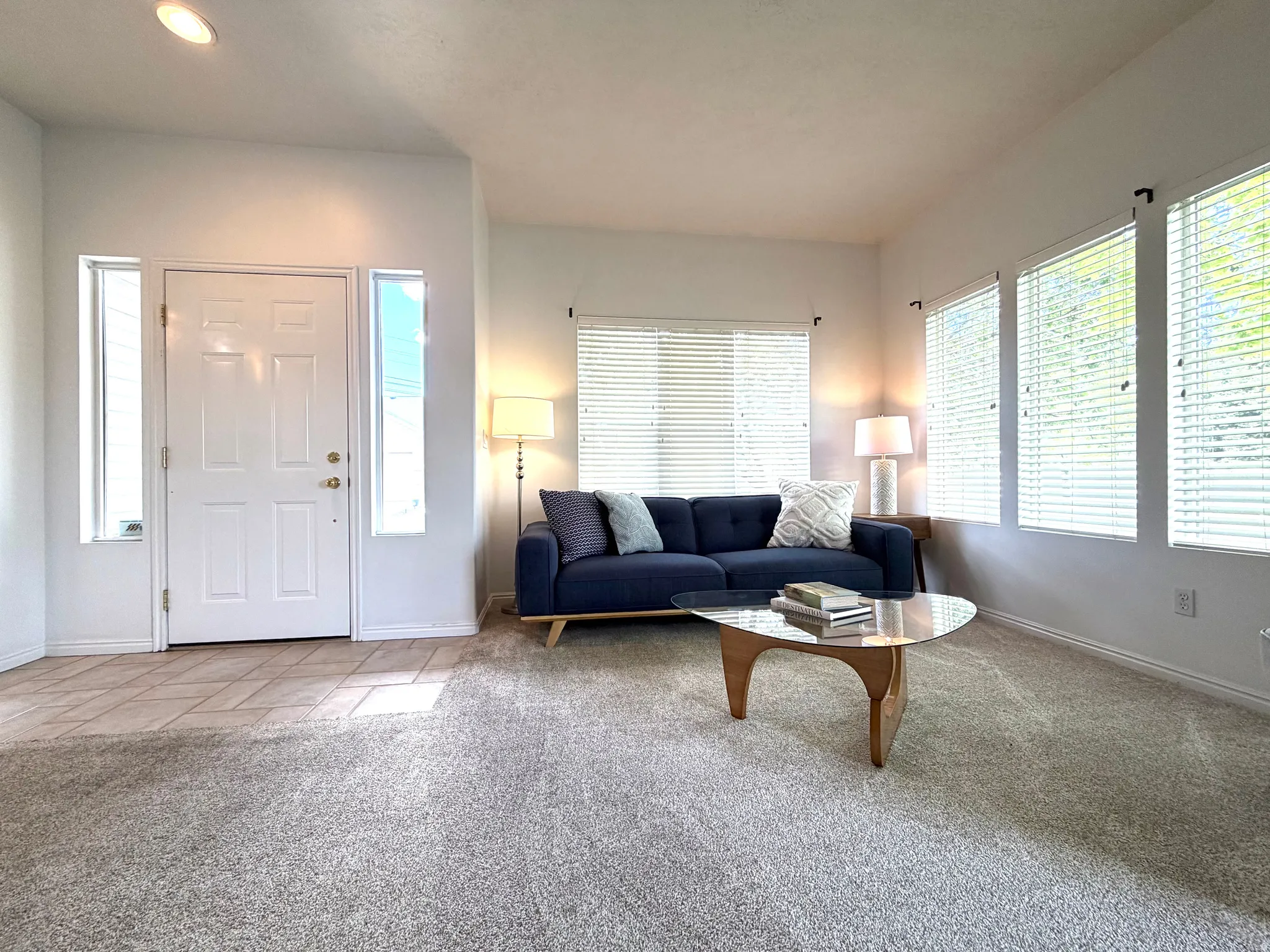 Entryway featuring a white paneled door with sidelight windows, tile flooring, and recessed lighting
