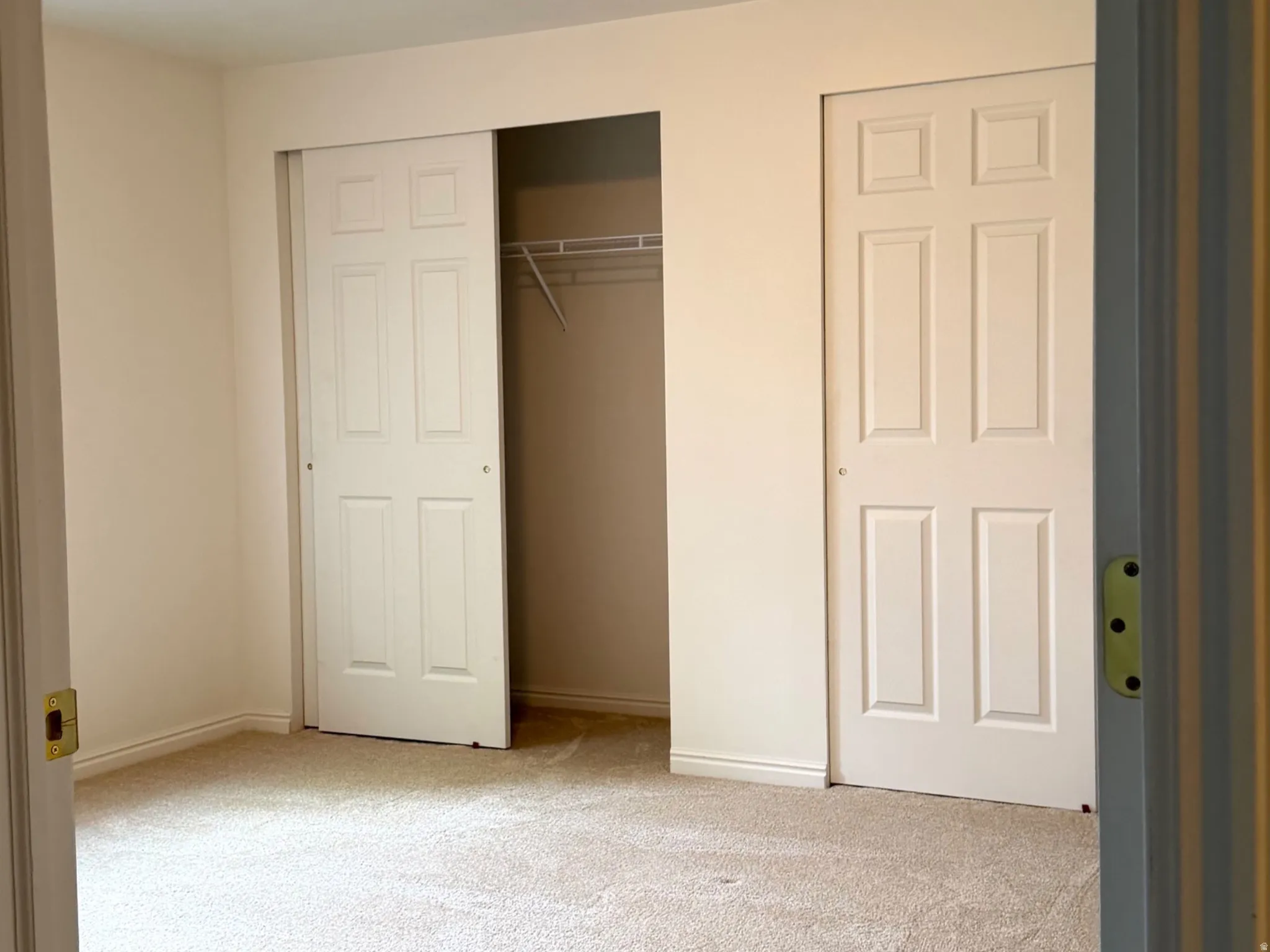 Carpeted interior space featuring neutral wall paint and a flush-mount ceiling light fixture