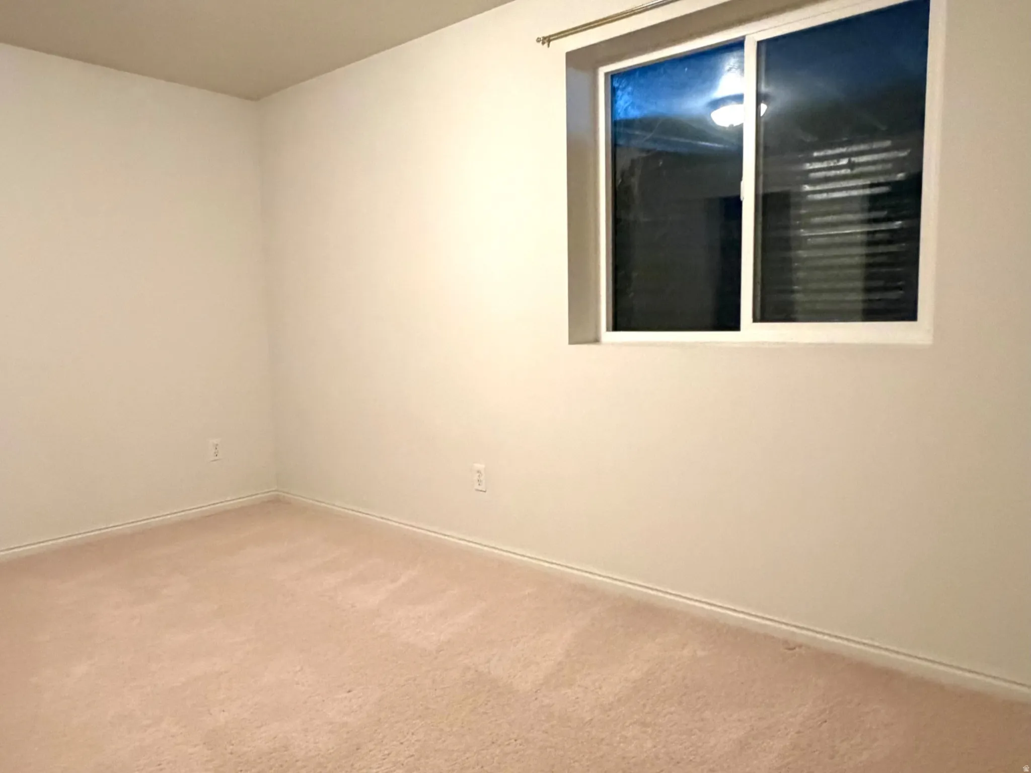 Room featuring light-colored wall-to-wall carpeting, white baseboards, and neutral-toned painted walls