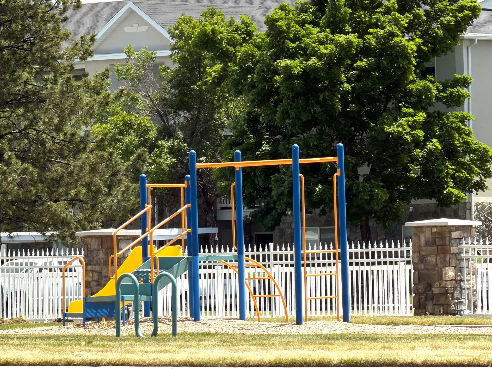 Community playground featuring a slide, climbing bars, and a swing set
