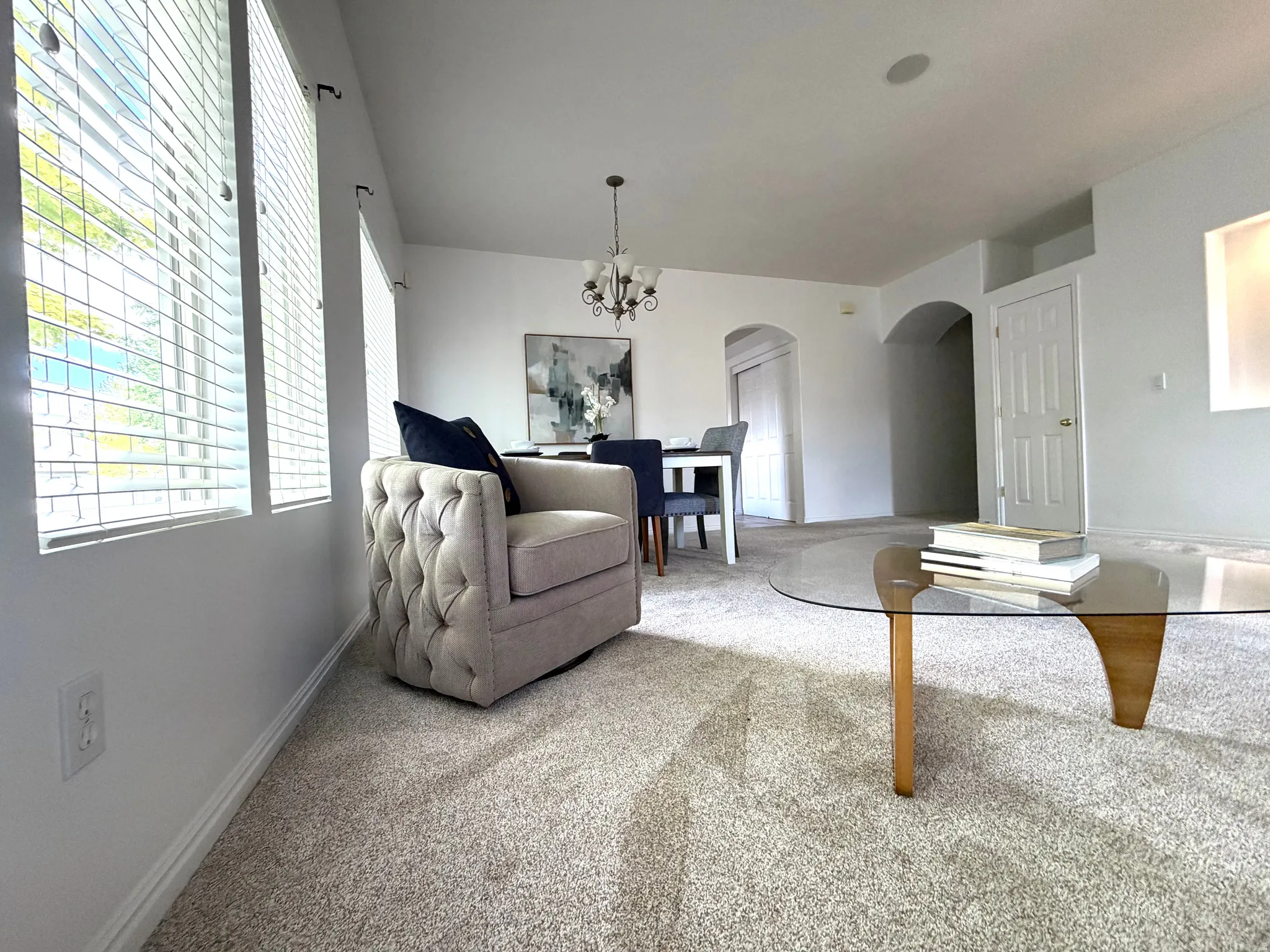 Open living space featuring light-colored carpeting throughout