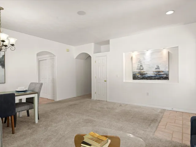 Carpeted living space with a recessed art niche featuring integrated lighting