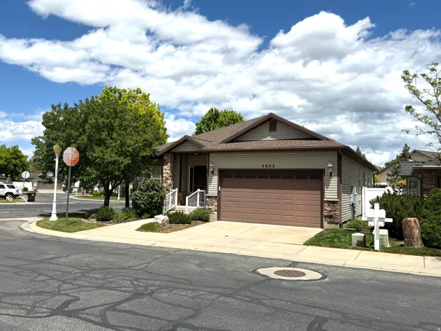 Single-story residence featuring light tan siding and a brown composite roof