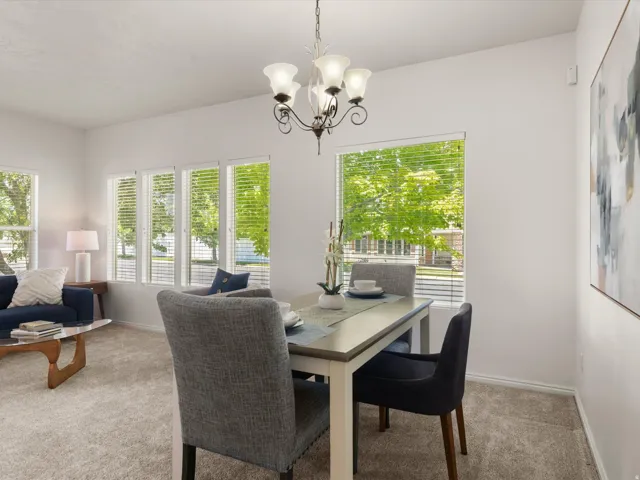 Dining area featuring a classic chandelier and multiple windows with horizontal blinds