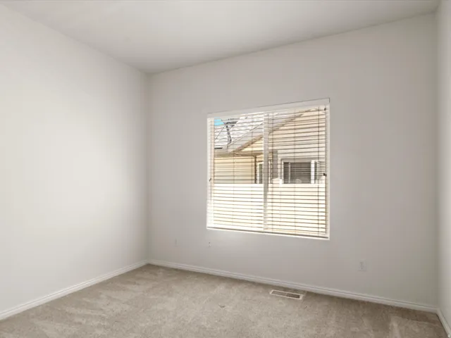 Room featuring a window with horizontal blinds, light-colored carpet, and white baseboards