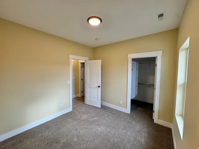 Carpeted room with neutral wall paint and white trim