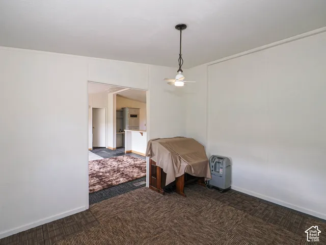 Room featuring neutral wall paneling and textured carpet