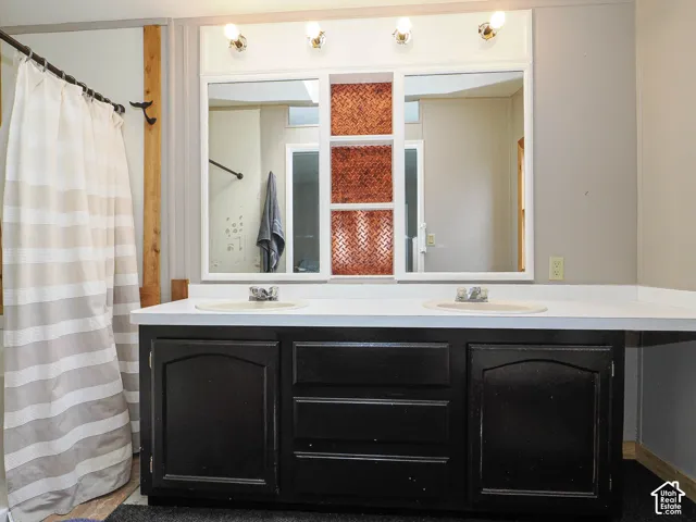 Dual vanity with solid surface countertop, integrated sinks, and black cabinetry