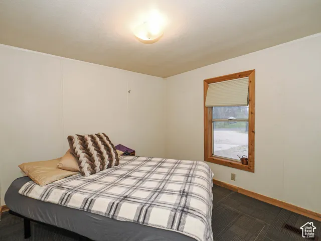 Recessed lighting illuminates an interior space featuring a window with natural wood trim and a light-filtering blind