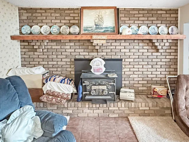 Brick-clad fireplace with a wood-finish mantel and integrated wood-burning stove