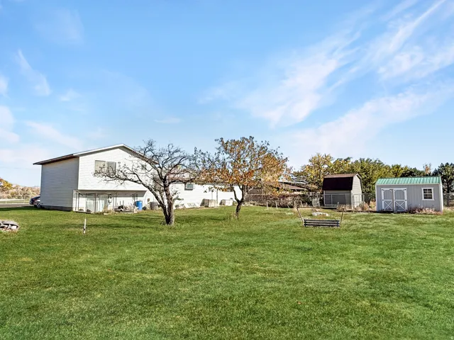 Expansive green lawn surrounding a two-story residence with white siding