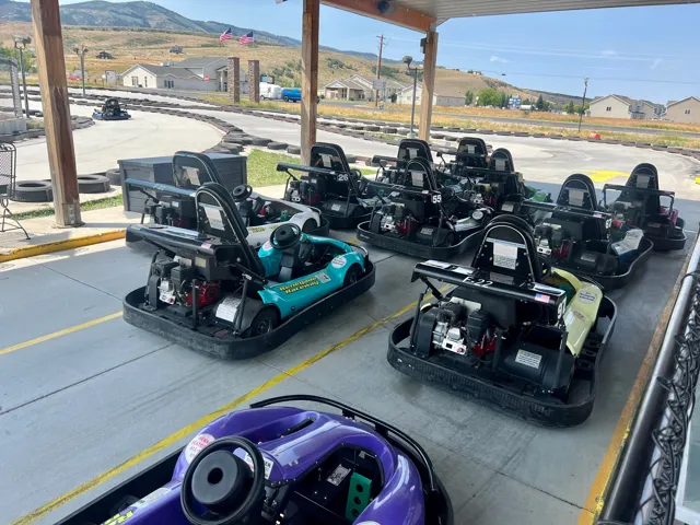Covered outdoor area featuring multiple go-karts parked on paved ground