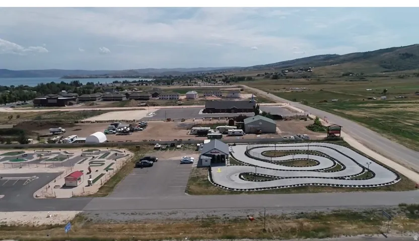 Aerial perspective showcasing a sprawling property featuring a go-kart track, miniature golf course, and multiple commercial structures