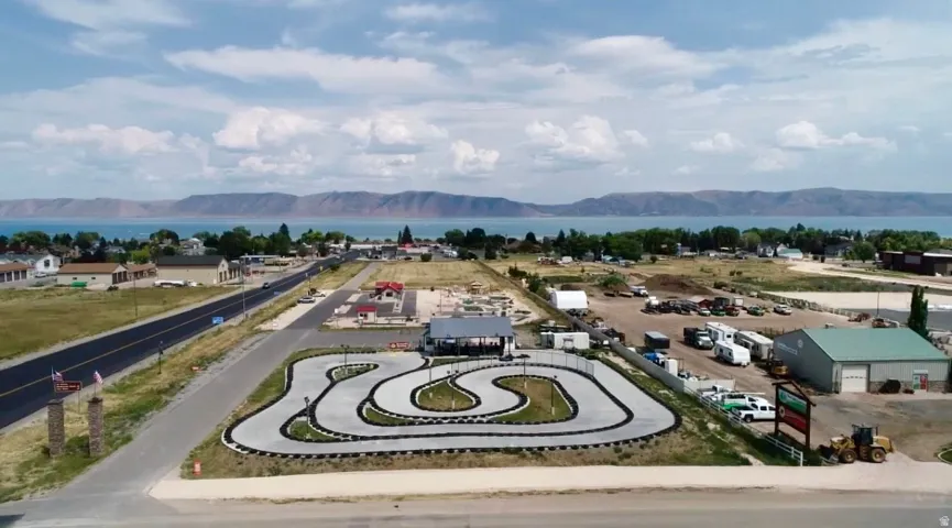 Aerial perspective showcasing a go-kart track with a paved surface and tire barriers