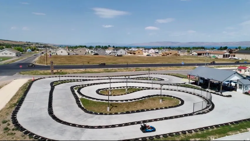 Concrete go-kart track with tire barriers and perimeter fencing