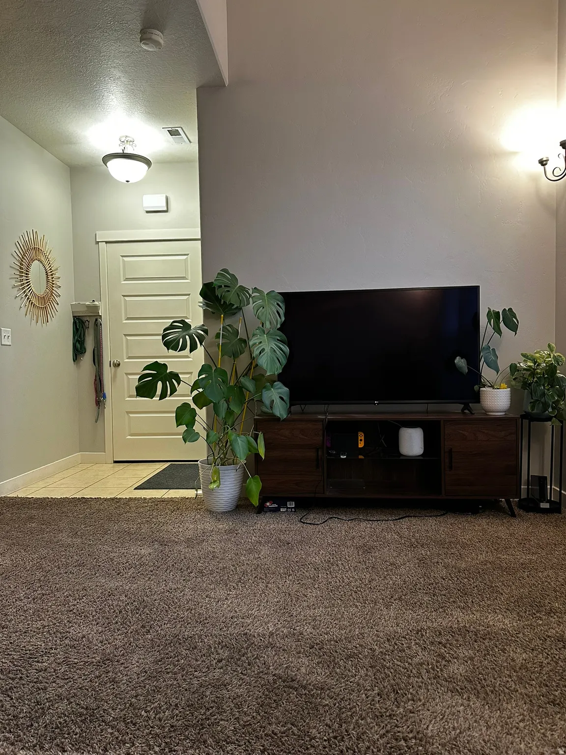 Spacious living area featuring plush carpeting and a neutral wall color