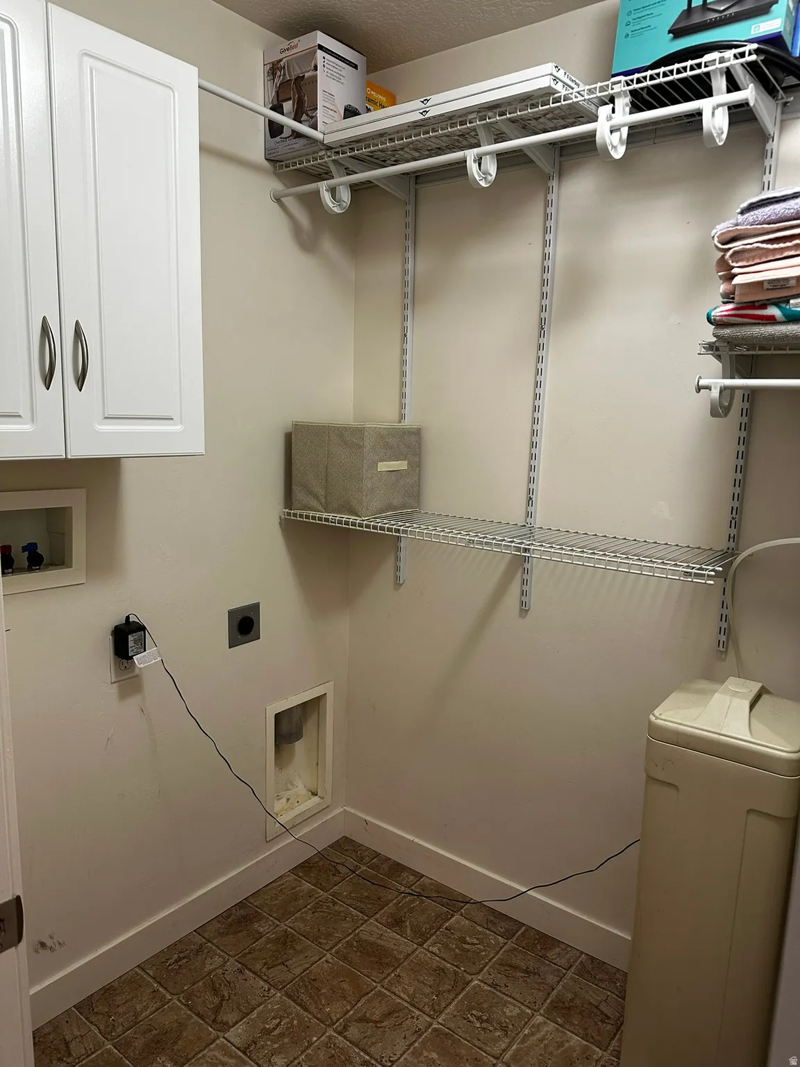 Dedicated utility space featuring tile flooring and neutral wall tones