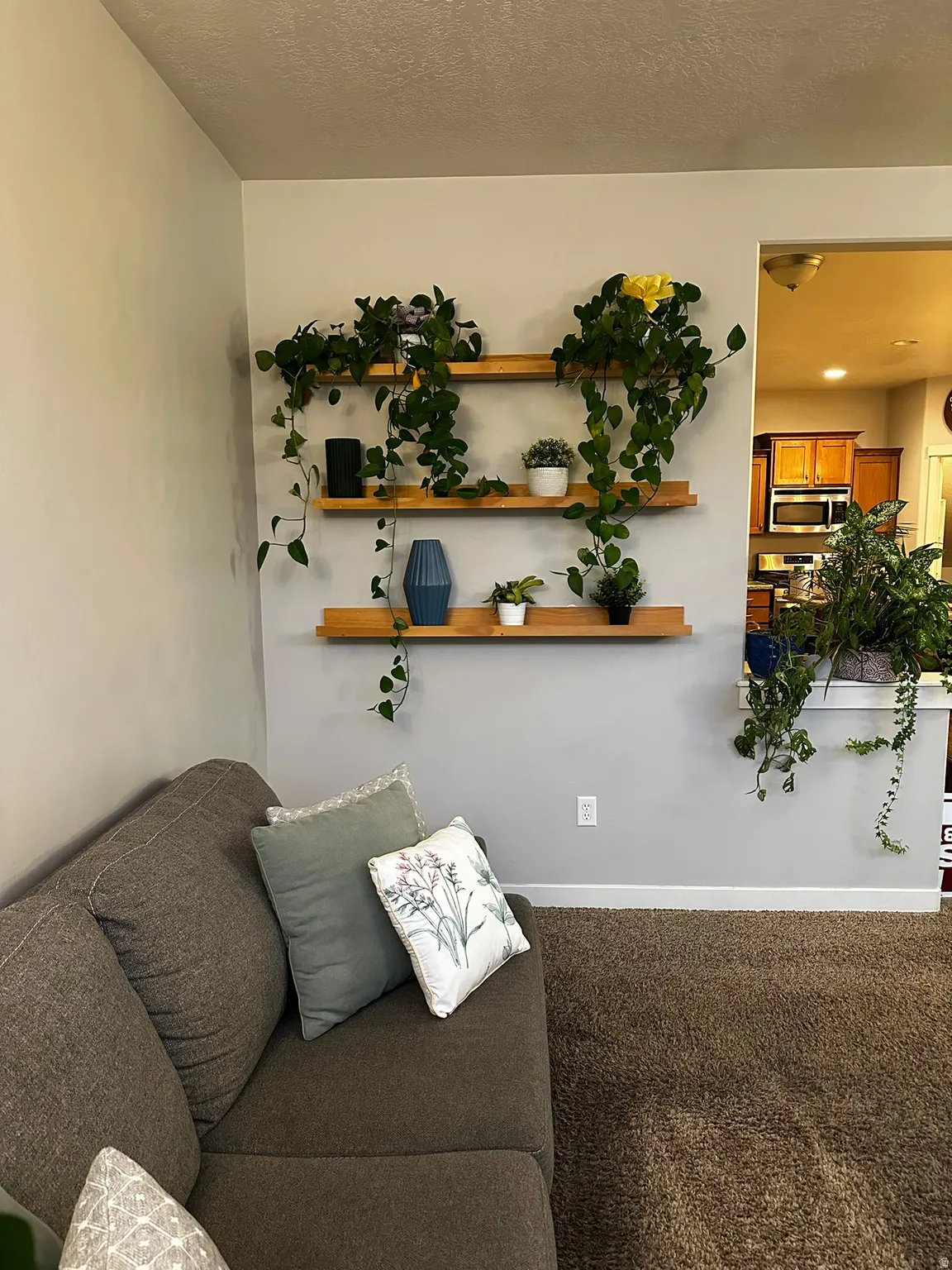 Light gray wall with three integrated wooden floating shelves