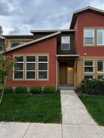 Contemporary multi-level residence featuring a red siding exterior with tan trim accents