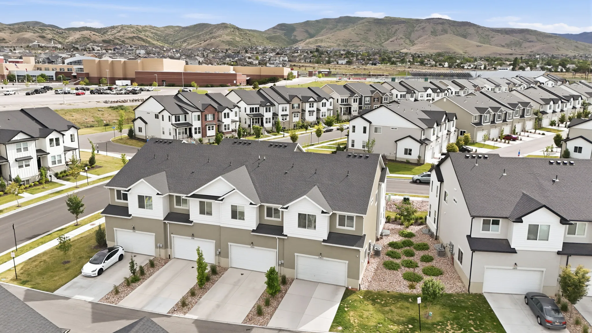 Modern townhome development featuring multiple units with white garage doors and private driveways