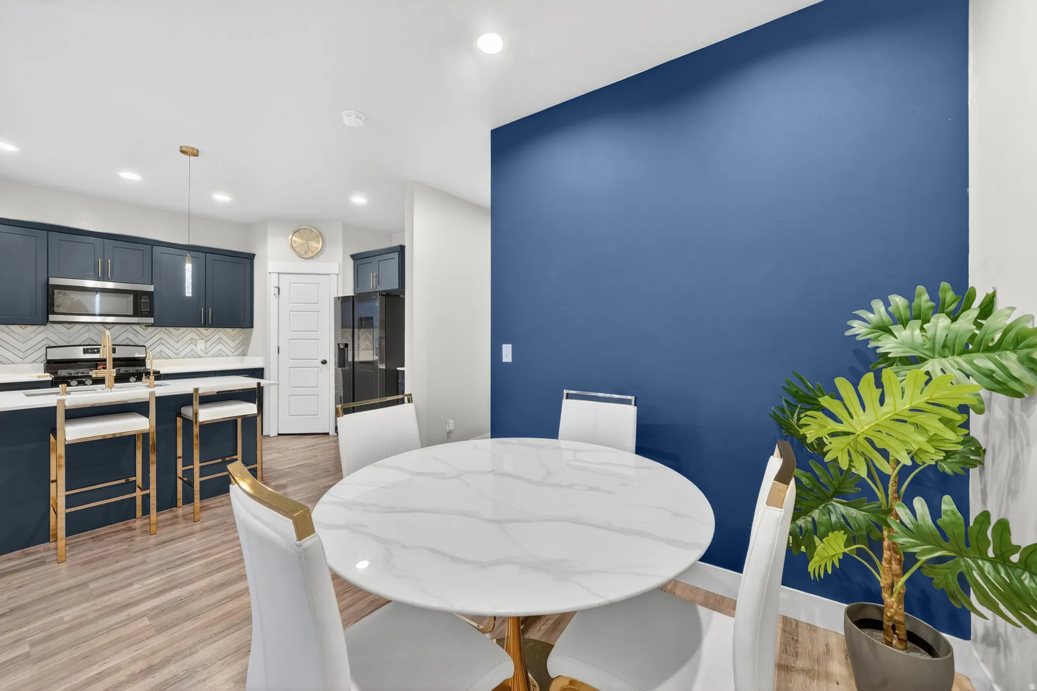 Open-concept dining area featuring a striking blue accent wall