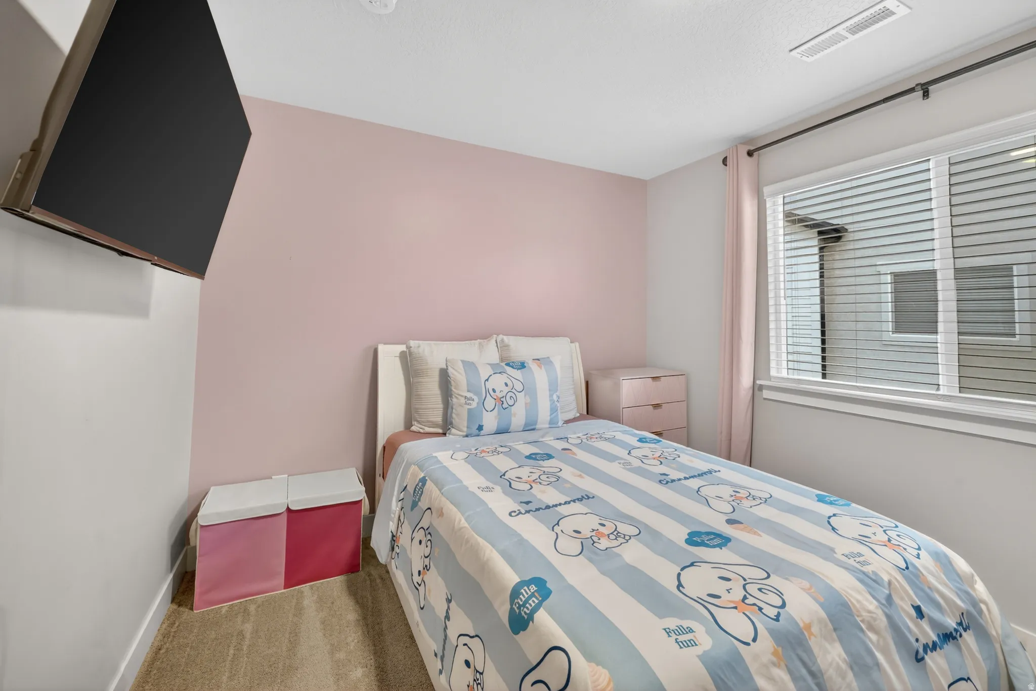 Bedroom featuring a white bed frame, light pink accent wall, window with horizontal blinds, and a mounted flat-screen television