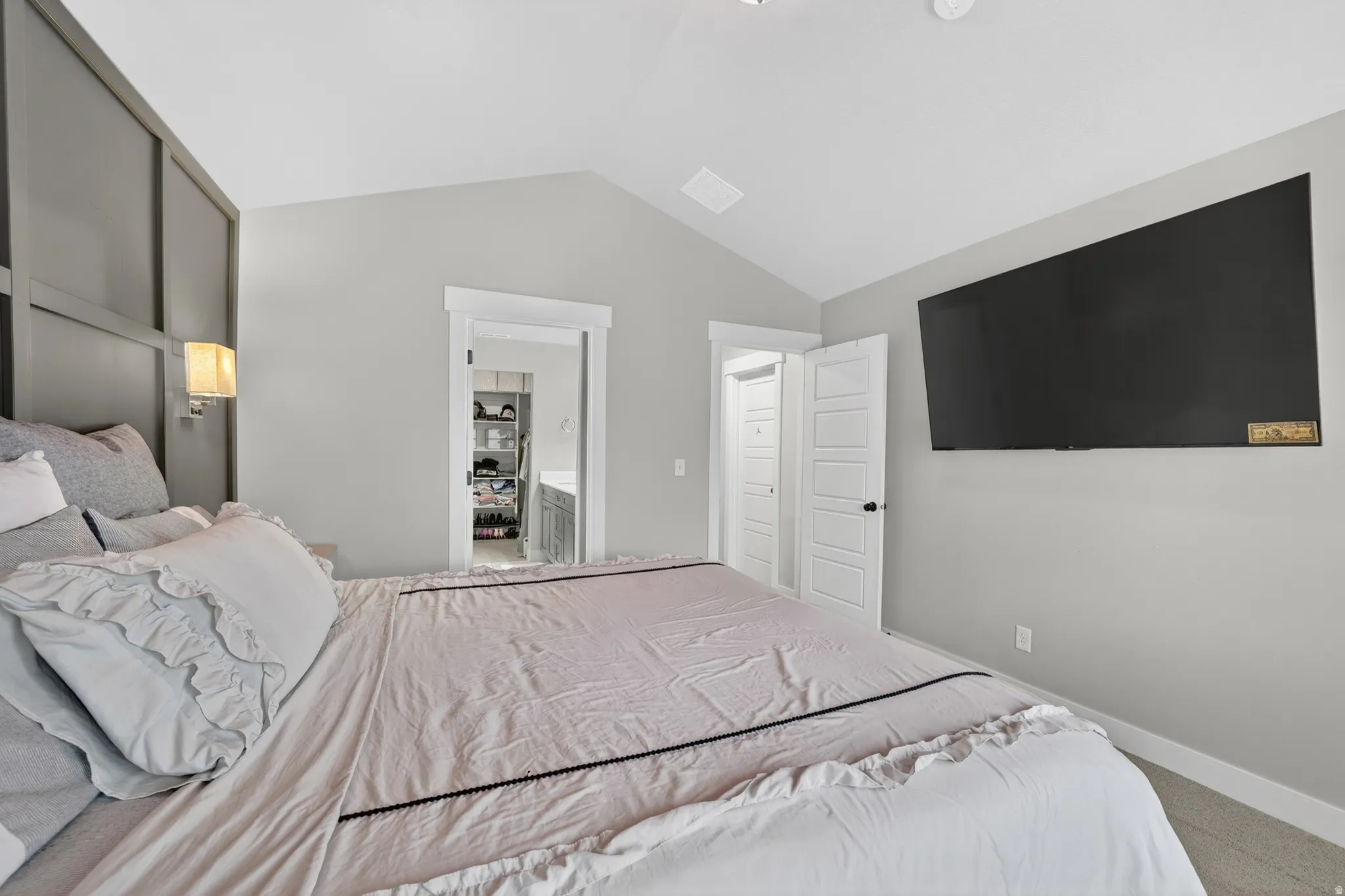 Bedroom featuring an accent wall with wainscoting, vaulted ceiling, and recessed lighting