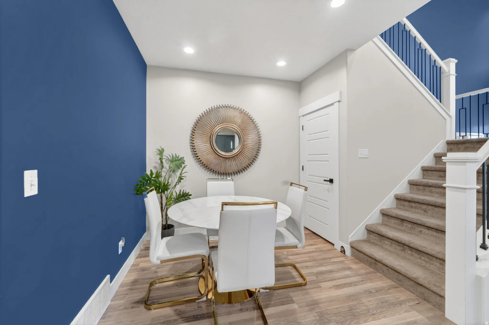Dining area featuring a bold accent wall, recessed lighting, and wood-finish flooring