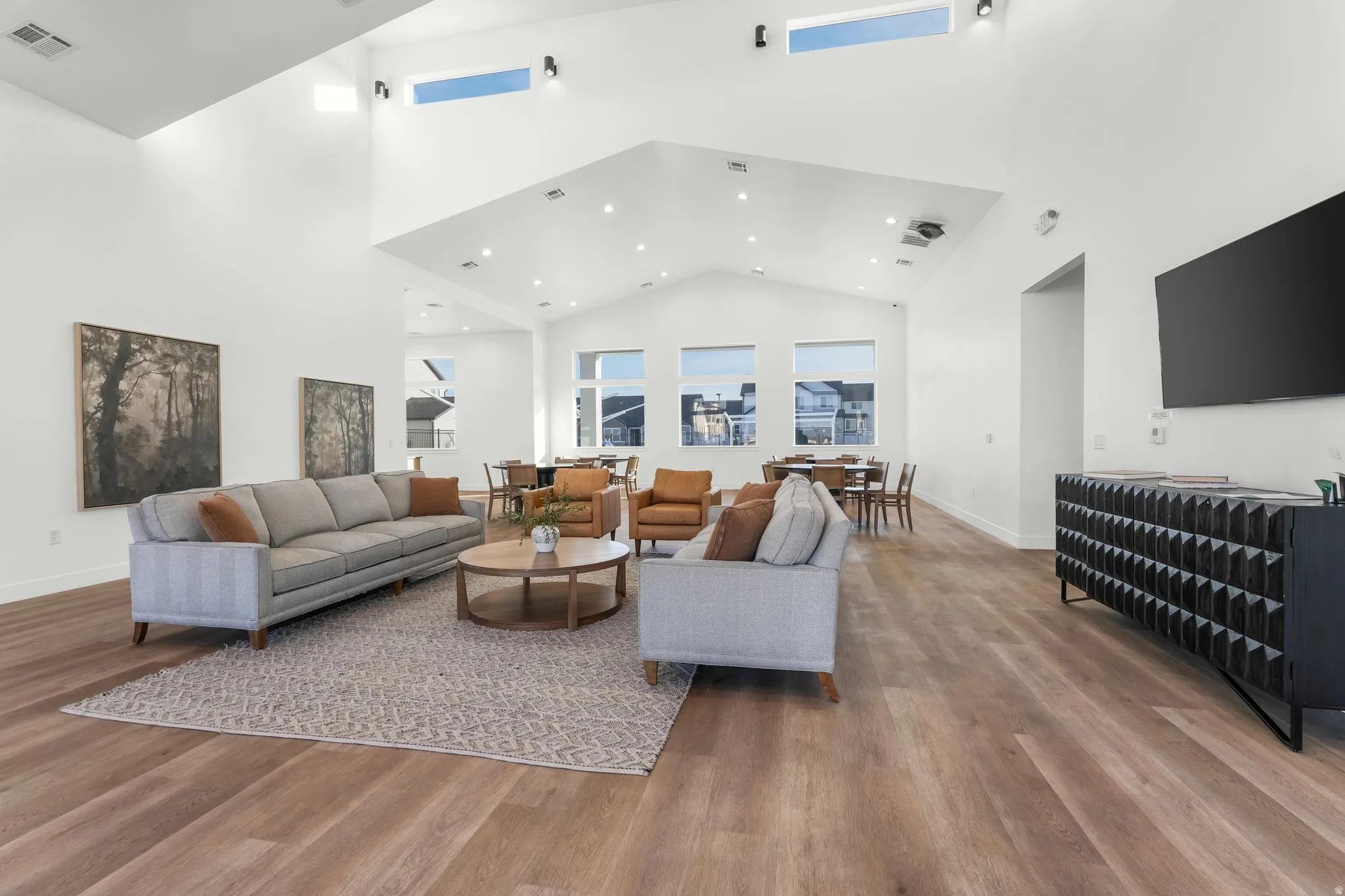 Expansive living area featuring vaulted ceilings with high transom windows and recessed lighting