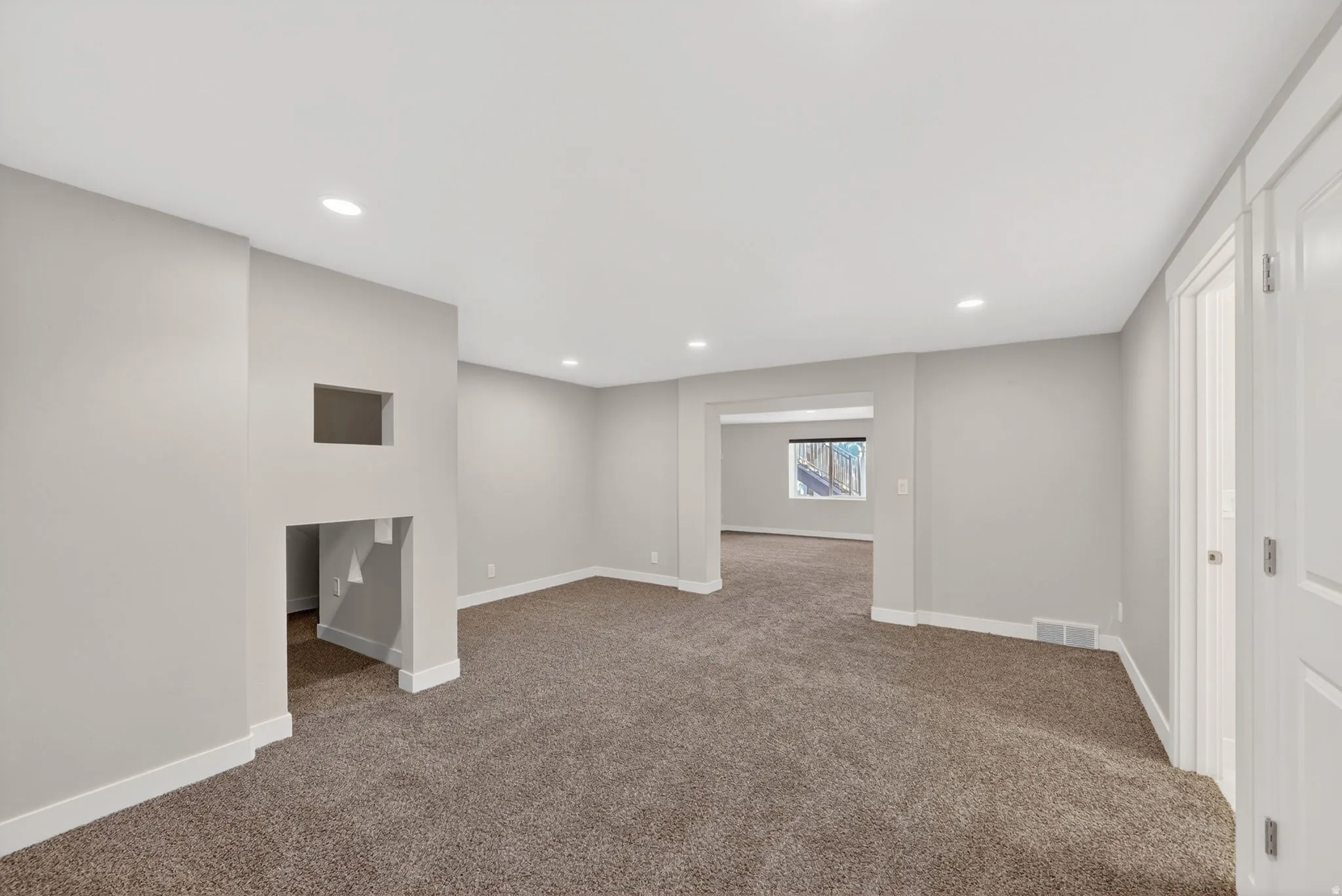 Spacious interior with neutral wall paint and plush carpet flooring