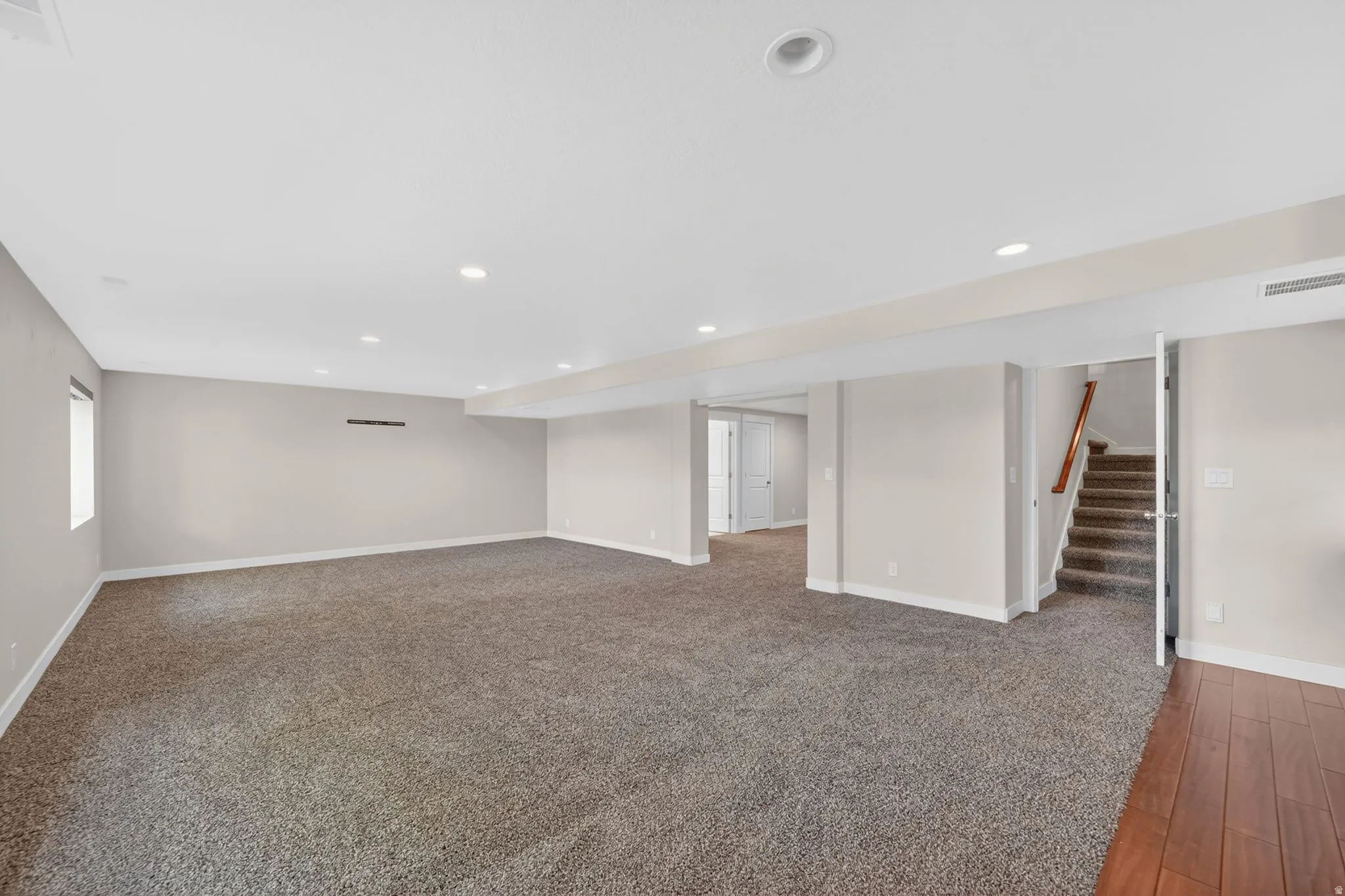 Spacious room featuring neutral carpeting and light-toned walls