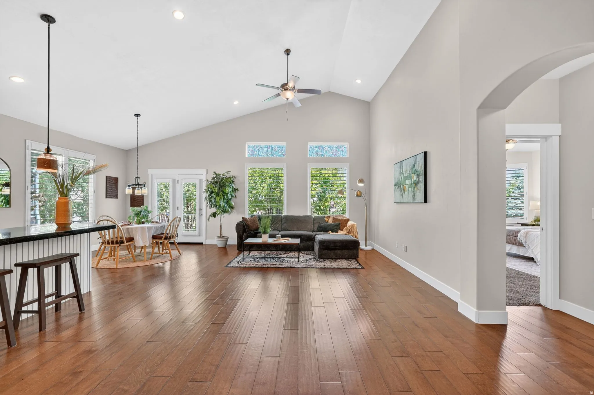 Open-concept living area featuring wood-finish flooring, a vaulted ceiling, and recessed lighting