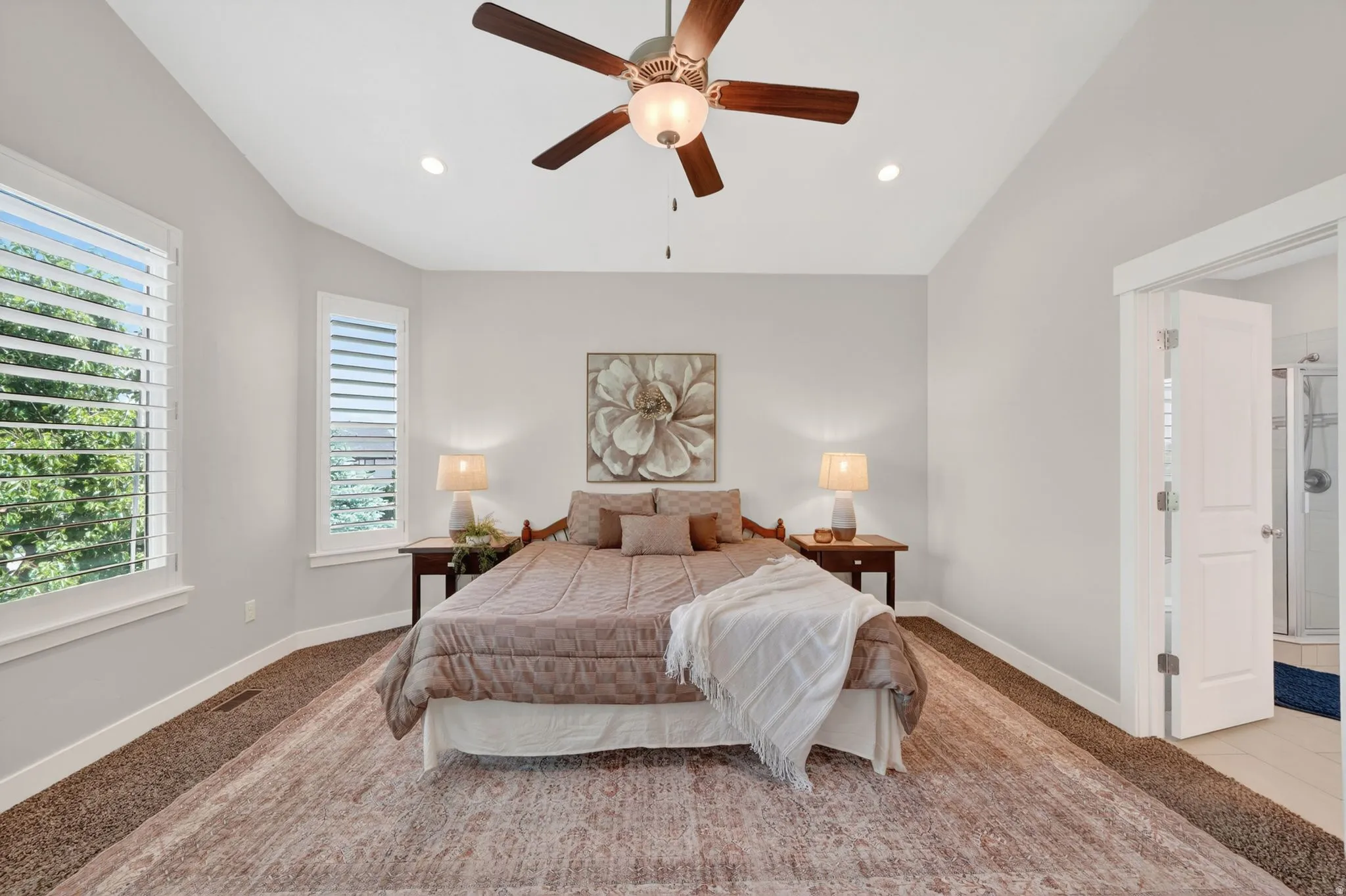Vaulted ceiling bedroom with a ceiling fan, recessed lighting, and plantation shutters
