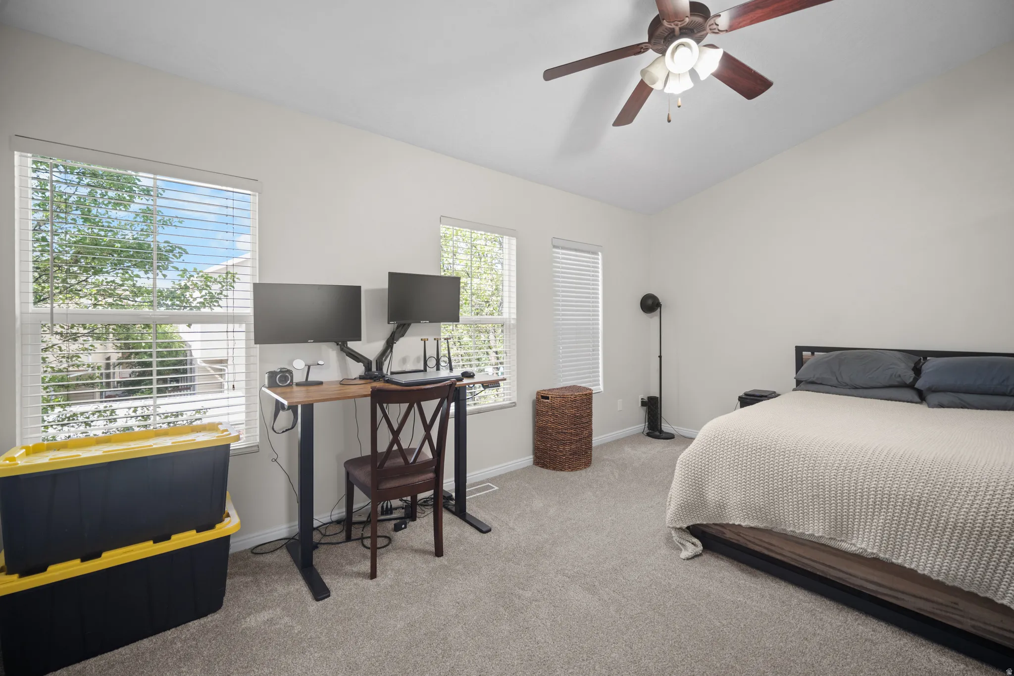 Carpeted room featuring a vaulted ceiling with a ceiling fan
