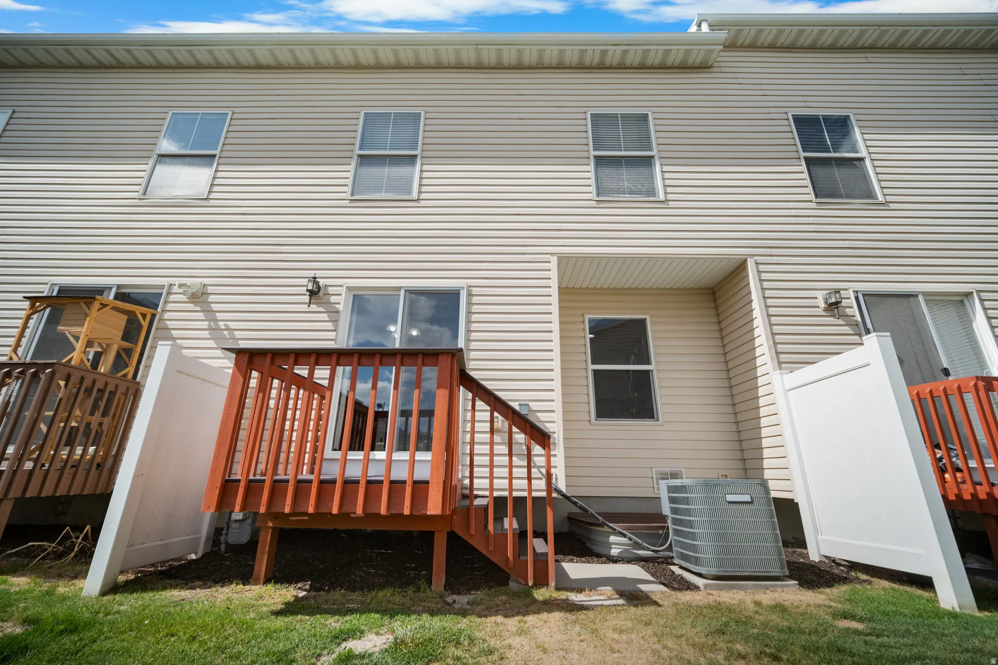 Rear exterior featuring light-colored horizontal siding and multiple windows