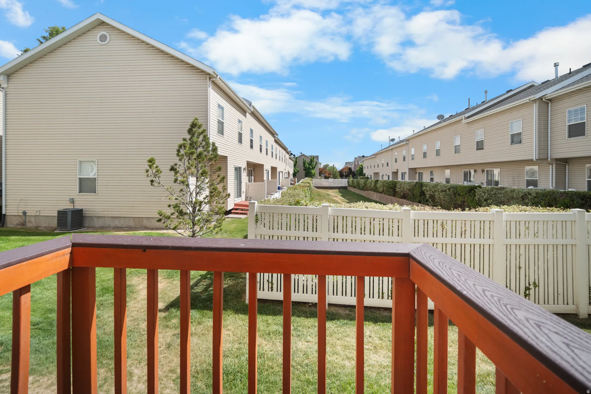 Spacious backyard with a white privacy fence and a manicured lawn