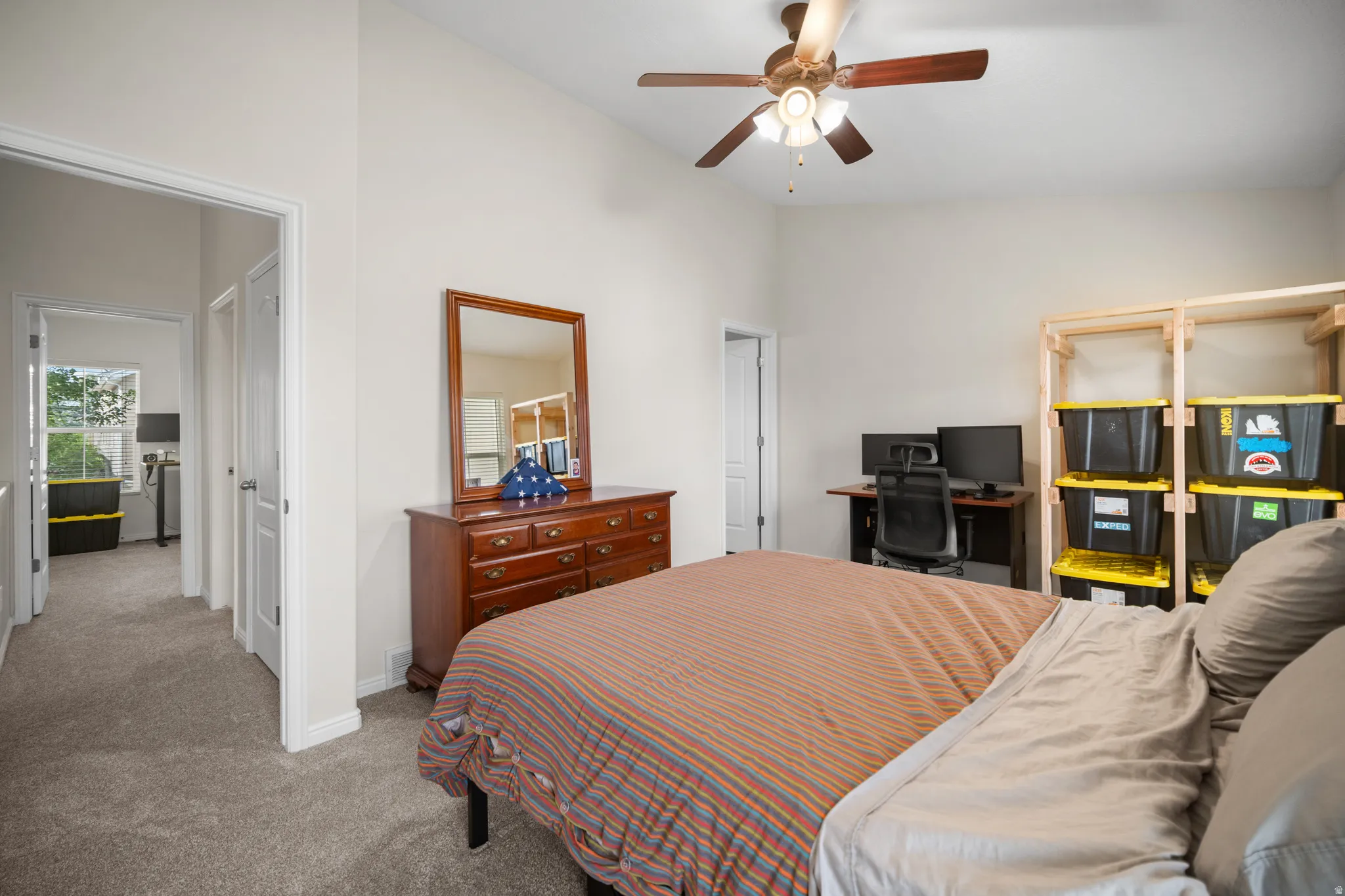 Carpeted bedroom with vaulted ceiling and ceiling fan