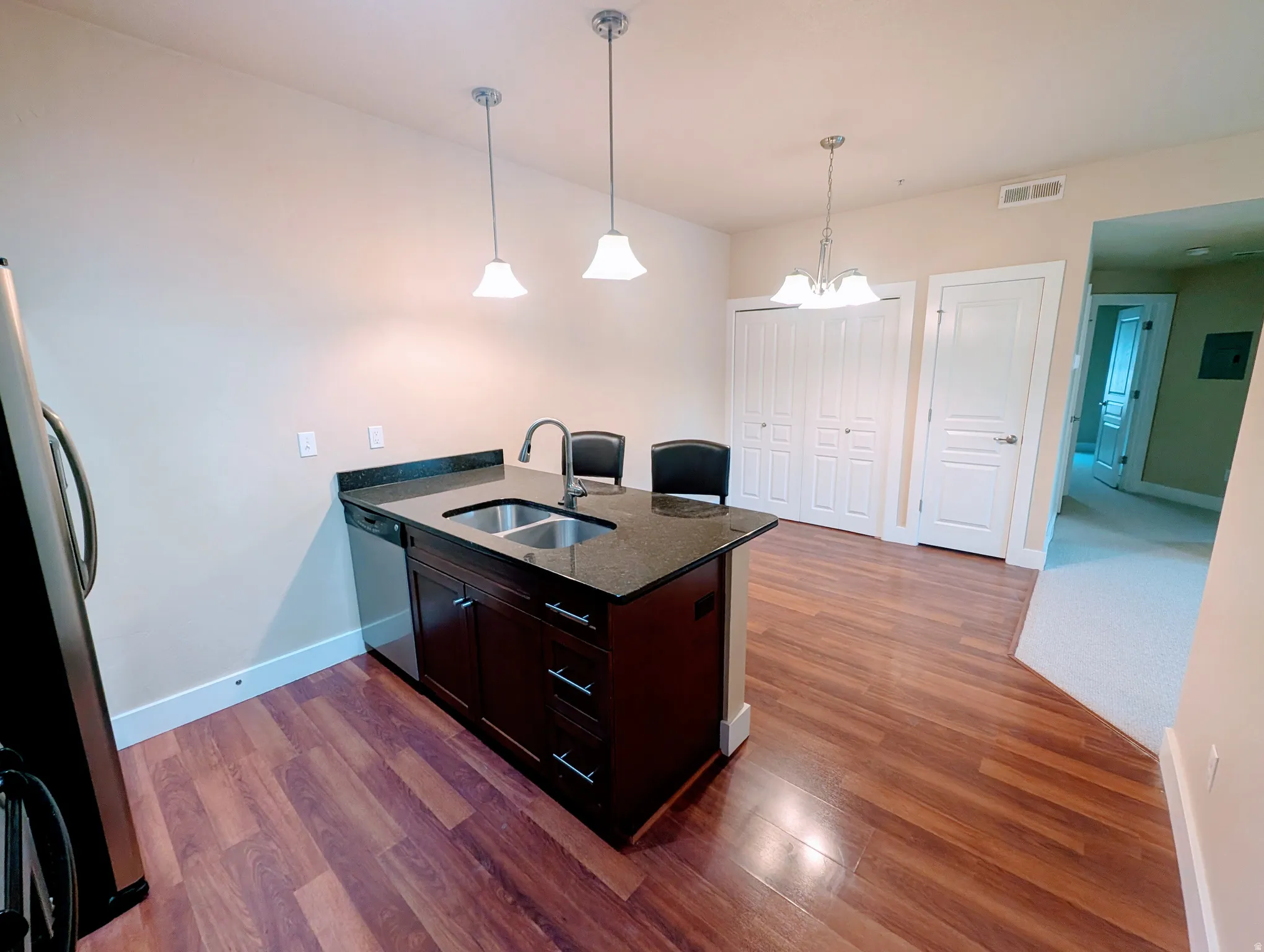 Kitchen island with a double basin sink and a dark countertop