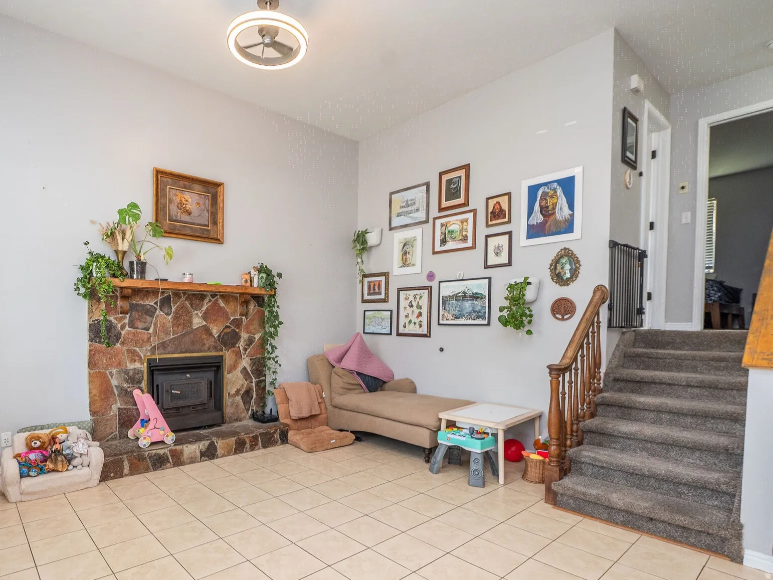 Living room with tall ceilings, cozy fireplace, & fun eclectic wall art.